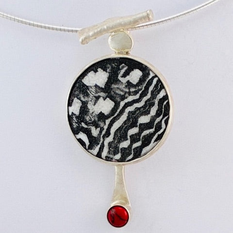 Black and white enamel pendant with red coral stone, handcrafted by Laura Haszard